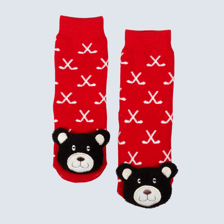 Two socks against a white background. The socks feature a red and white hockey stick motif and a cute plush bear charm on the toe.