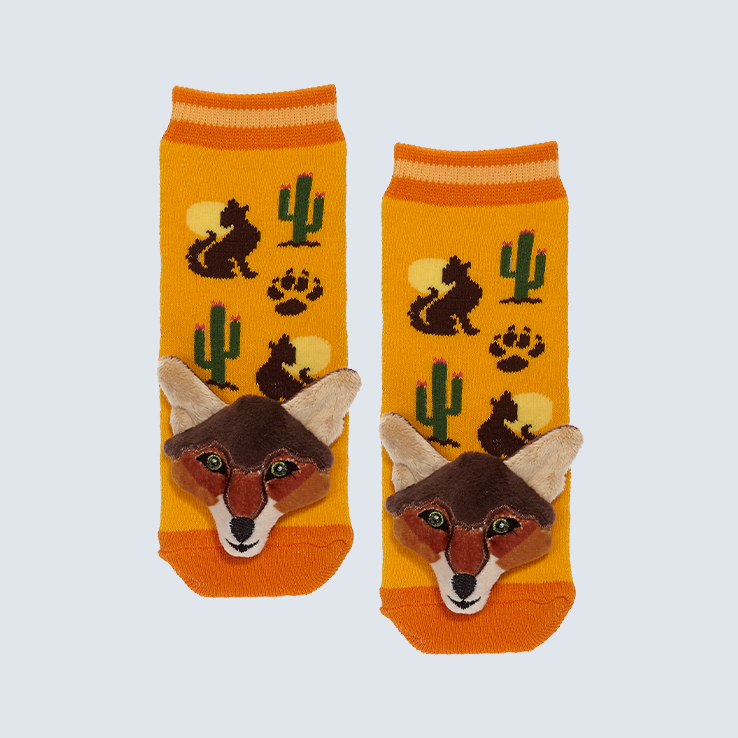 Two orange and yellow socks against a white background. The socks feature a howling coyote and cactus motif with a cute plush coyote charm on each toe.