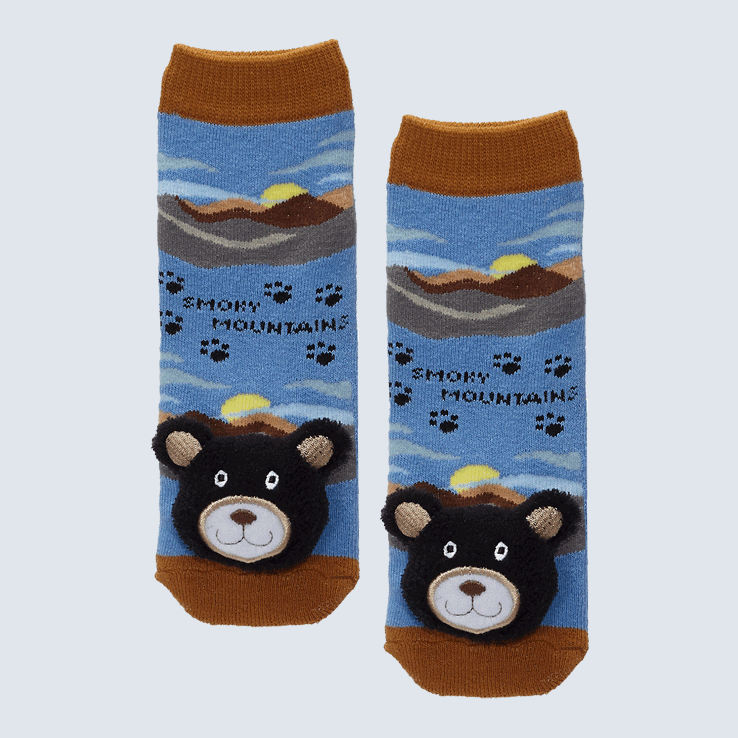 Two socks against a white background. The socks feature the Great Smoky Mountains and a plush bear charm on each toe.