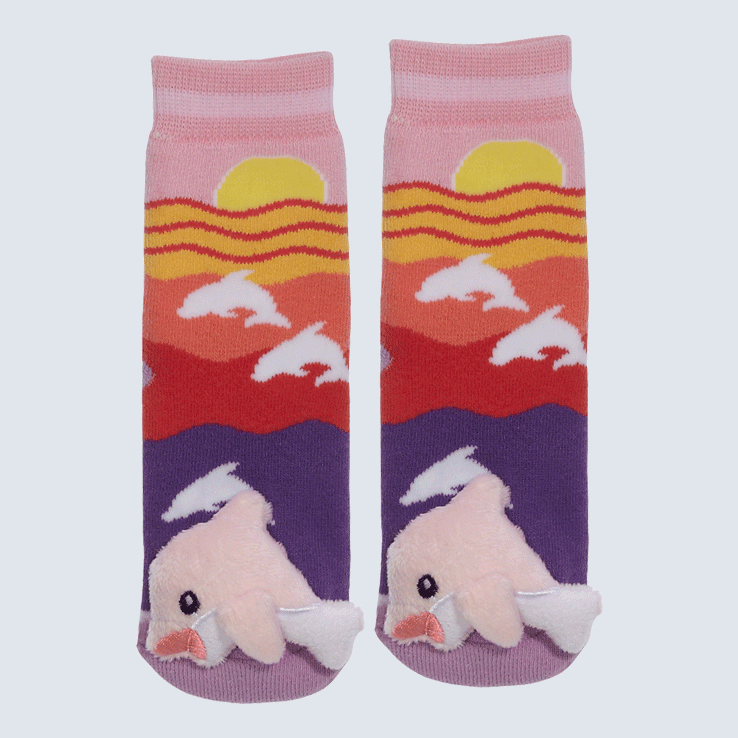 Two socks against a white background. The socks feature a sunset motif and a cute plush pink dolphin charm on the toe.