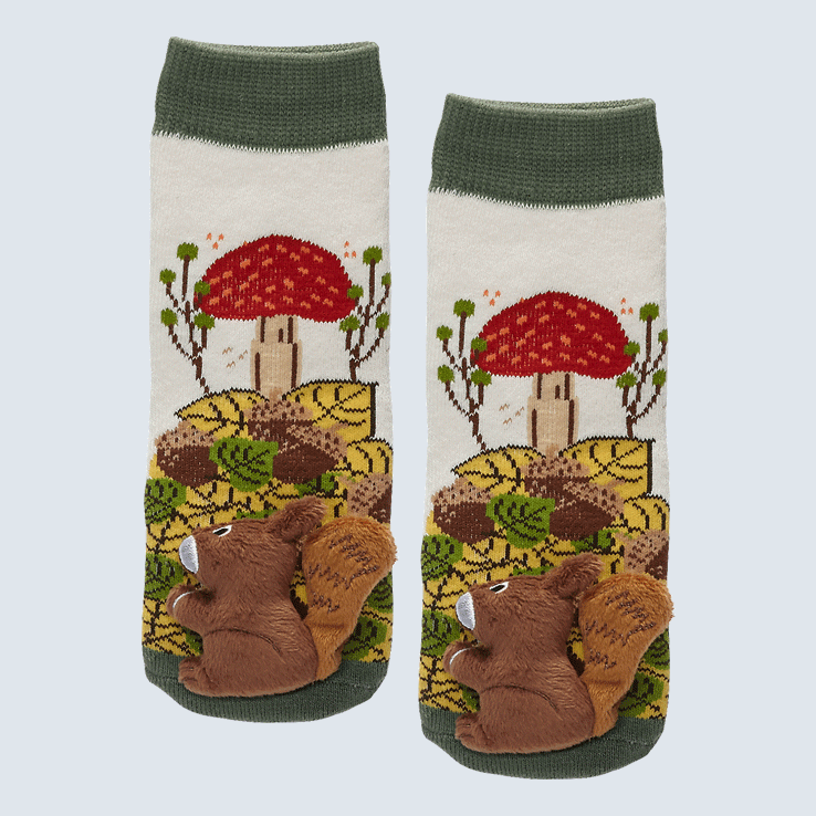 Two socks against a white background. The socks feature a mushroom and nature pattern. Each sock has a  cute plush squirrel charm on the toe.