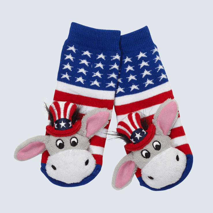 Two socks against a white background. The socks feature an American flag pattern and a cute plush donkey charm on the toe.