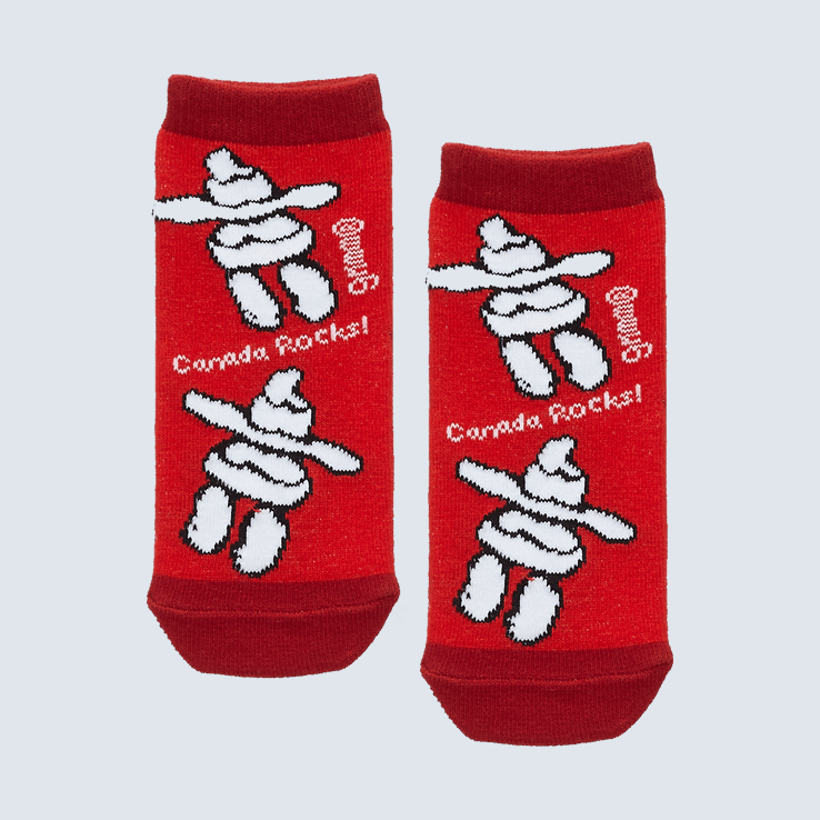 Two small red socks against a white backdrop. The socks feature the words Canada Rocks and a pattern featuring a inukshuk design.